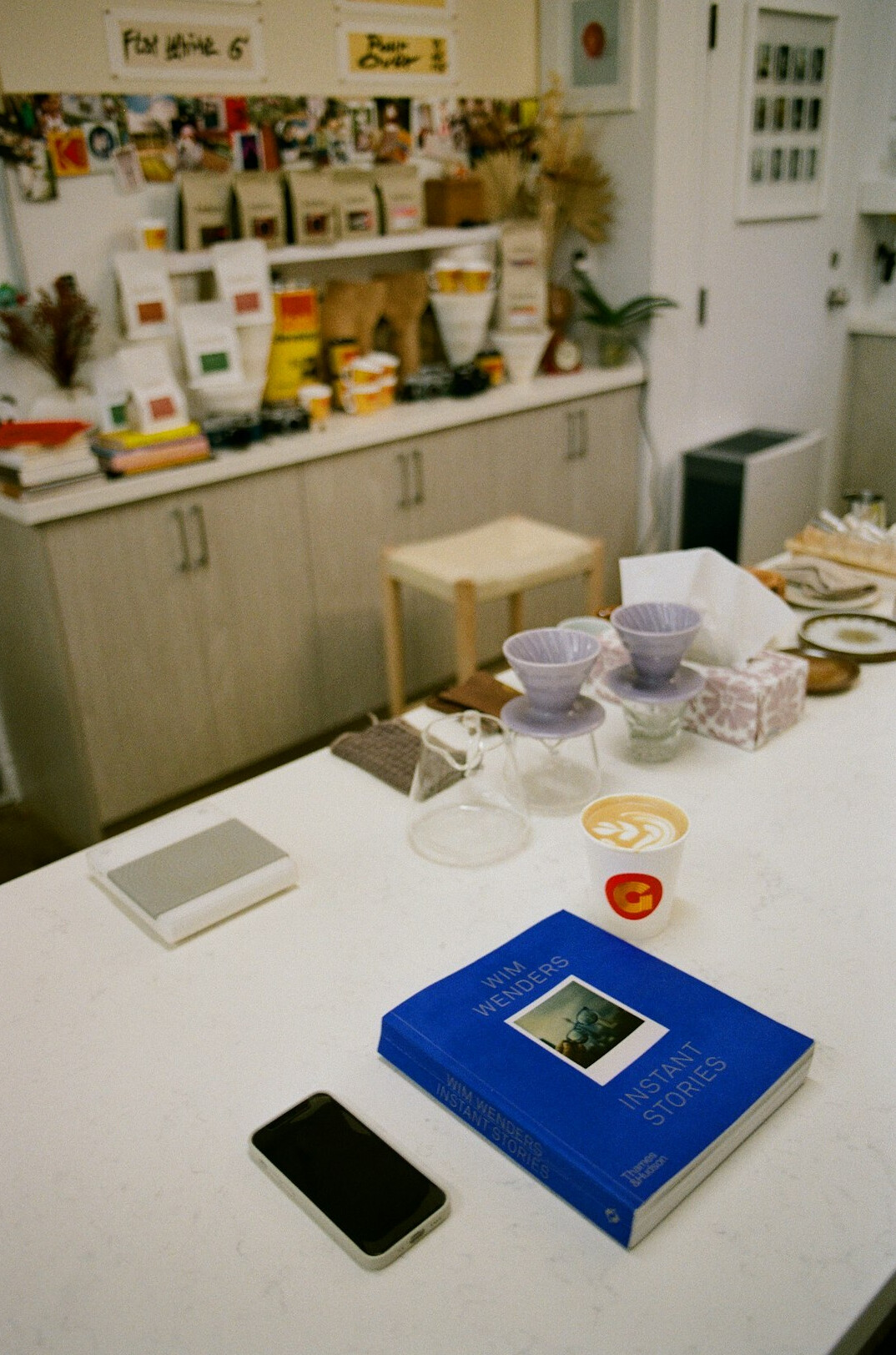 A table covered with printed photographs and notebooks documenting queue stories